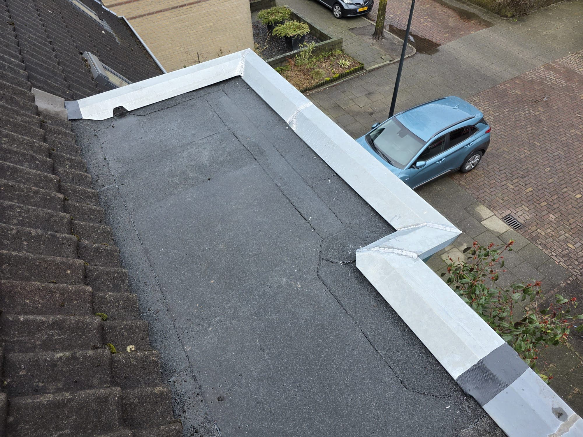 Plat dak met nieuwe zinken daktrim rondom.